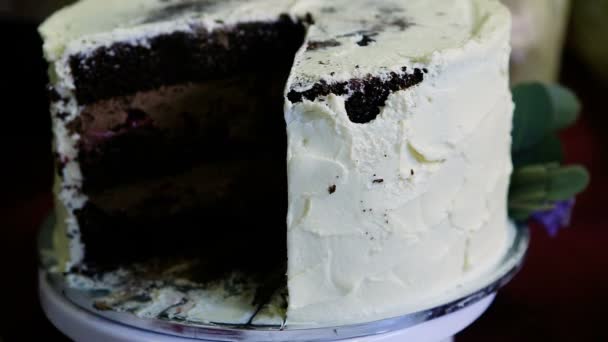 Aşağı Panorama büyük çikolata kek üzerine beyaz krema ile dekore edilmiştir. — Stok video