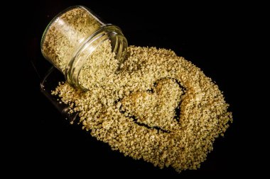 Üstten Görünüm kalp yeşil organik deniz tuzu küçük cam kavanozdan dışarı dökülür boyalı