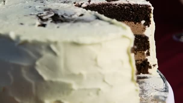 Closeup μεγάλο κέικ σοκολάτας, διακοσμημένα με λευκή κρέμα περιστροφές γύρω από — Αρχείο Βίντεο