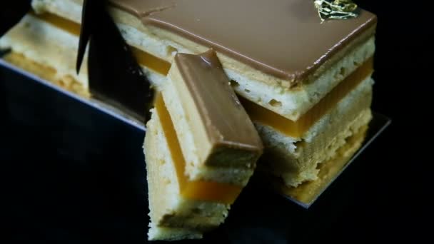 Closeup sliced piece of multilayer caramel cake decorated with chocolate — Stock Video