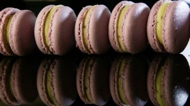 closeup violet Fransız tatlılar macaron birlikte yeşil krem dolum satırda kenarında siyah ayna arka plan yansıması ile