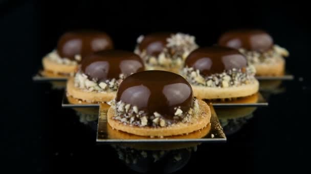 フランス語のズームインするのセットにミニ ムース デザート菓子チョコレート艶出しで覆われ 三角形の形で提供しています — ストック動画