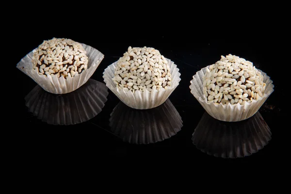Rij van drie nuttige ronde handgemaakte snoepjes met sesamzaadjes — Stockfoto