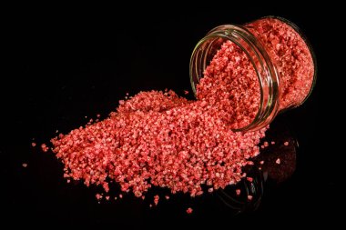 büyük pembe organik deniz tuzu küçük cam kavanozdan dışarı dökülür