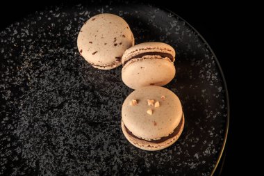 siyah plaka üzerinde çikolata ile çekim üç fıstık Makaron