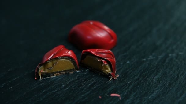 Closeup Bütün Kesme Karamel Dolgulu Çikolata Şekerleme Servis Siyah Tablo — Stok video