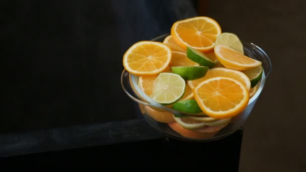 Fresh orange and lime circle slices served it deep bowl — Stock Video
