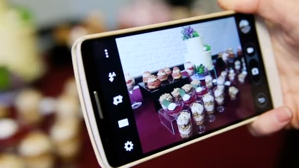 Closeup hands take phone pictures of assorted desserts — Stock Video
