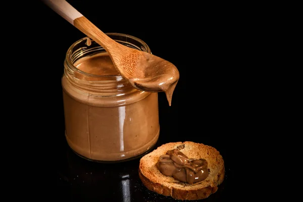 Top view closeup peanut butter in glass jar and small cracker — Stock Photo, Image