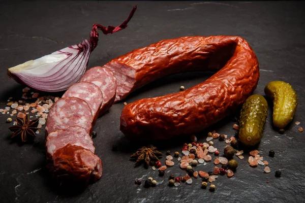 Нарізане коло смачної сухої ковбаси з маринованими огірками та цибулею — стокове фото
