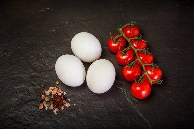 baharat ve domates ile üç beyaz tavuk yumurtası üzerinde üst görünümü