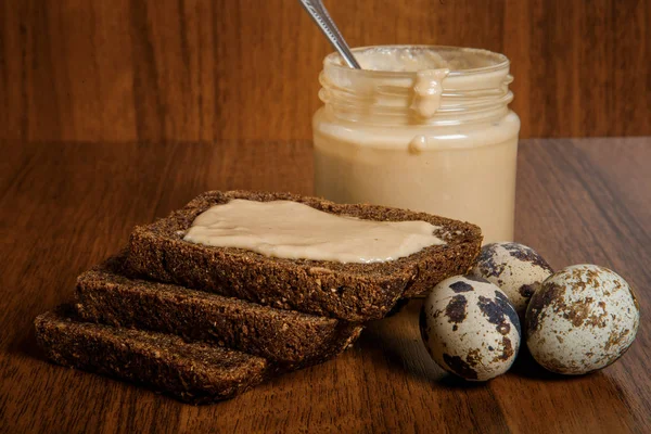 Small glass jar of homemade tahini sesame seeds butter with spoon — Stock Photo, Image