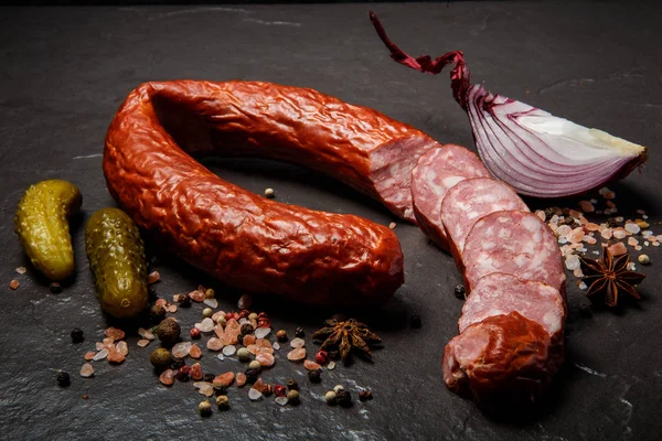 Делікатесна копчена ковбаса з маринованими огірками та цибулею — стокове фото