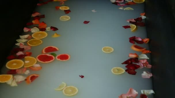 Fokus Auf Heißes Bad Mit Milch Zitrusscheiben Rosenblüten — Stockvideo