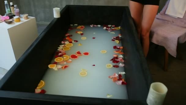 Chuda Dziewczyna Rzuca Plasterki Cytrusowe Płatki Róż Czarnej Kąpieli — Wideo stockowe