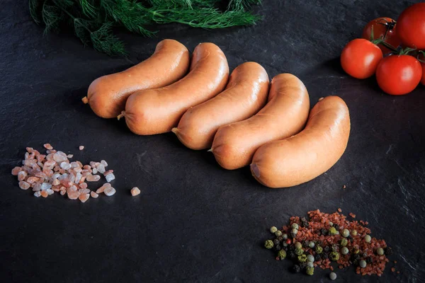 Вид зверху ряд коротких товстих ковбас з кропом і помідорами — стокове фото