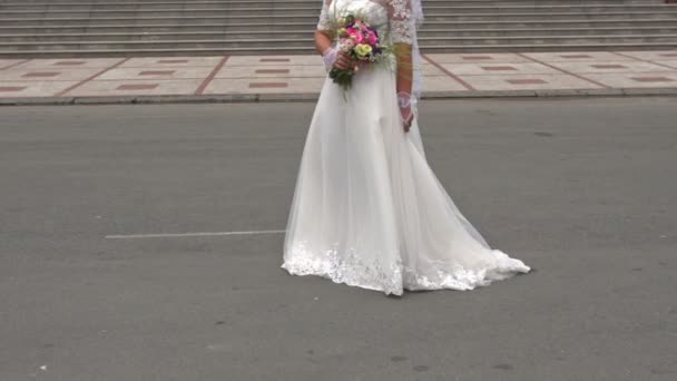 Η νύφη με το μακρύ φόρεμα στέκεται στην είσοδο του θεάτρου όπερας — Αρχείο Βίντεο
