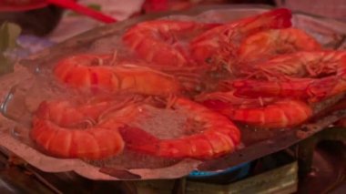 Yakın plan büyük kırmızı kaplan karidesleri açık ateşte metal tavada kızarıyor.