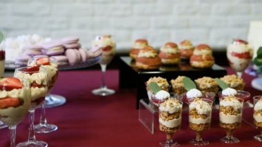 Şekerlemelerde yavaş yavaş panorama, çeşitli kremalı tatlılar ve çiçeklerle süslenmiş büyük beyaz pasta.