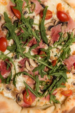 arugula, jambon ve domates ile bütün pizza üst görünümü makro
