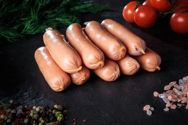 Крупним планом купа сирих довгих ковбас з руколами та помідорами — стокове фото