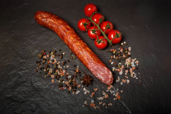 Вид зверху на довгу шматочок копченої ковбаси з помідорами — стокове фото