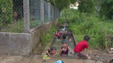 Nha Trang, Khanh Hoa/Vietnam - 03 Temmuz 2016: Vietnamlı çocuk banyo ve taş su için pirinç tarlalarının Köy evlerinde yeşil çim karşı 03 Temmuz Nha trang sağlayan canal oynamak