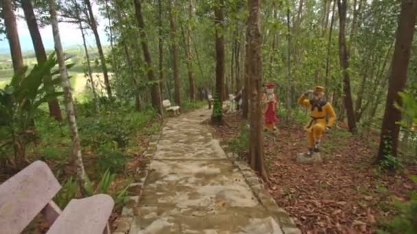 Kamera Parktaki Yüksek Tropikal Ağaçlar Arasındaki Çizgi Karakter Heykelleriyle Taş — Stok video