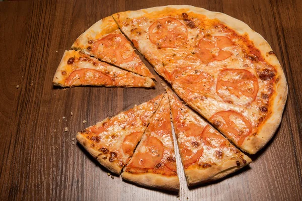 delicious sliced on pieces pizza with tomato slices