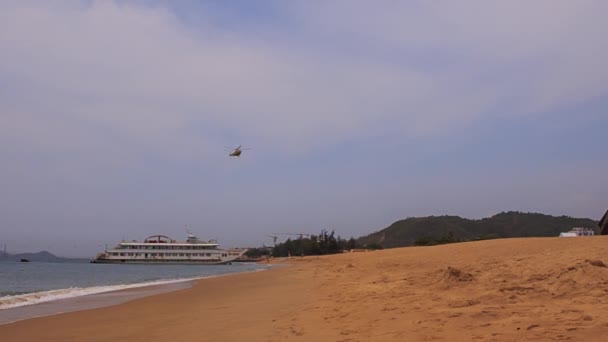 View of tourist vessel near beach and flying above helicopter — Stock Video