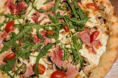 arugula, jambon, mantar ve domates ile pizza üst görünümü makro