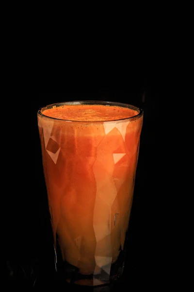 Zumo de naranja de zanahoria fresca cruda en vidrio plástico facetado alto —  Fotos de Stock