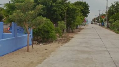 Nha Trang, Khanh Hoa / Vietnam - 26 Haziran 2016: Nha trang 'da 26 Haziran' da Vietnam 'da küçük evler arasında köy caddesi boyunca hareket eden kamera, villalar arasında tropik ağaçlar.