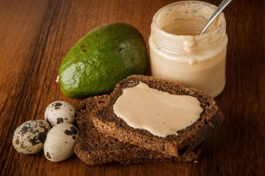 tahin, çavdar ekmeği, avokado, bıldırcın yumurtası ile üst görünümü closeup kavanoz