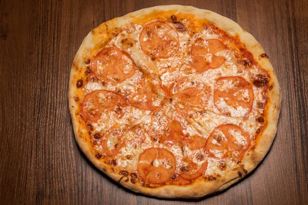 top view of whole round sliced pizza with tomato slices