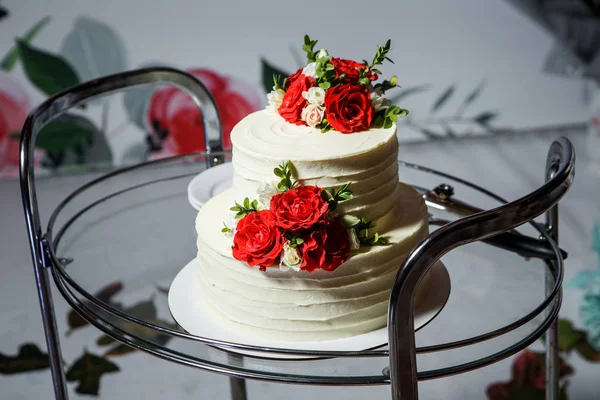 Bolo de casamento de duas camadas com rosas vermelhas na bandeja de vidro — Fotografia de Stock