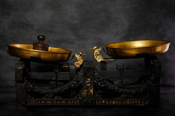Closeup escalas antiquárias com duas taças de ouro e peso velho — Fotografia de Stock