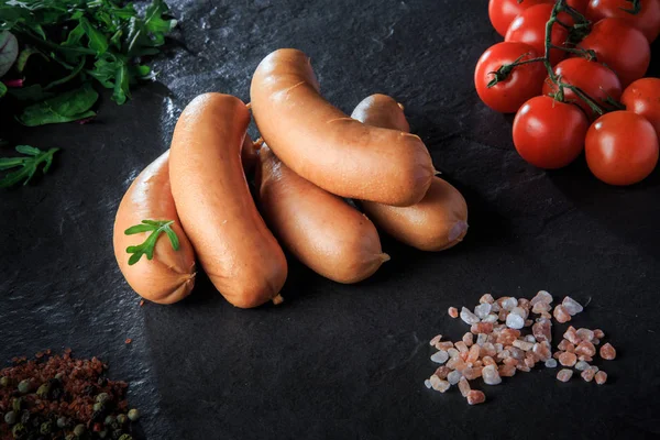 Набор коротких толстых колбас с руколой и помидорами — стоковое фото