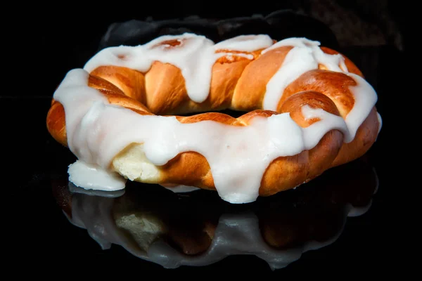 Closeup fresh baked bun with white caramel decoration — Stock Photo, Image