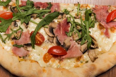 arugula, jambon ve domates ile pizza üst görünümü makro bir yarısı