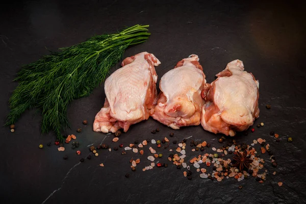 top view of three parts of raw chicken served with green dill