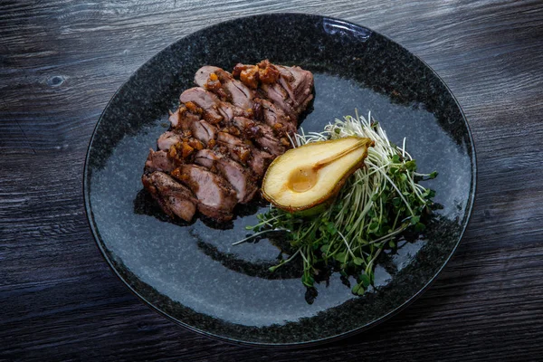 Deliciosas rebanadas de carne de res a la parrilla con la mitad de pera al horno — Foto de Stock