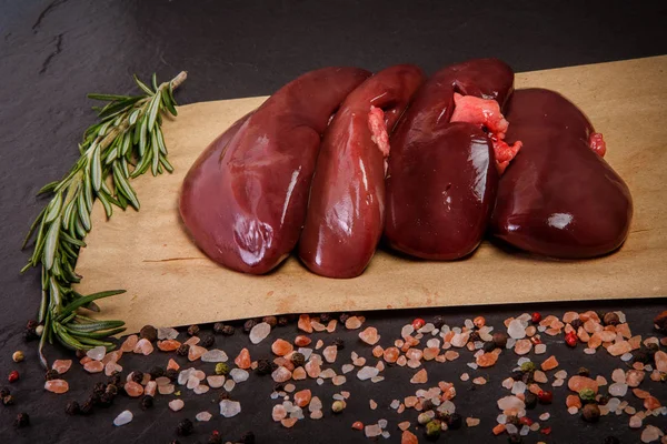 Group of raw pork kidneys served with spices and rosemary — Stock Image Group of raw pork kidneys served with spices and rosemary Stock Image
