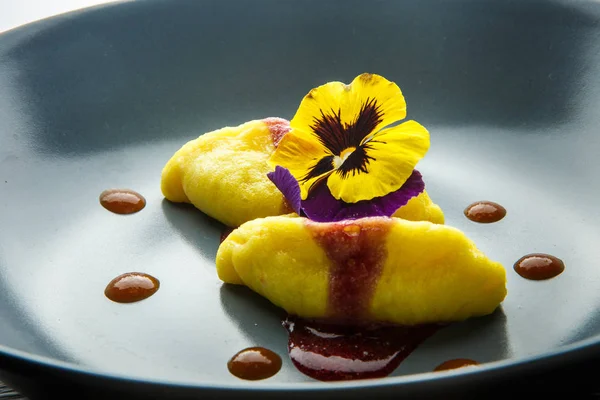 Fechar dois deliciosos bolinhos com molho vermelho e flor — Fotografia de Stock