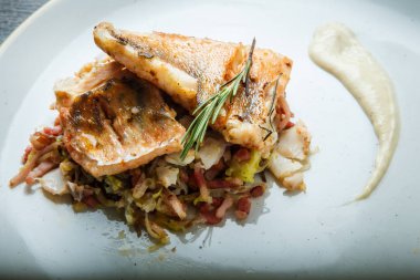 closeup iki kavrulmuş balık parçaları et salatası servis