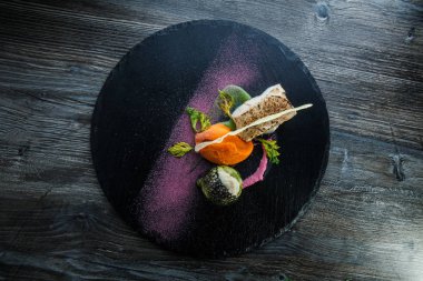 havuç püresi ile servis edilen kavrulmuş beyaz deniz balığı üst görünümü