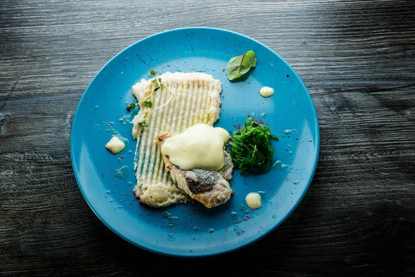 Top view on baked white fish fillet with potato puree and sea kale — Stock Photo, Image