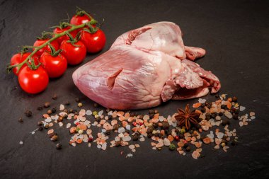 closeup büyük domuz çiğ kalp baharat ve domates ile servis
