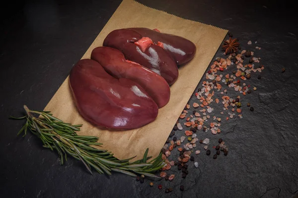 Top view on group of raw pork kidneys served on craft paper — Stock Image Top view on group of raw pork kidneys served on craft paper Royalty Free Stock Images
