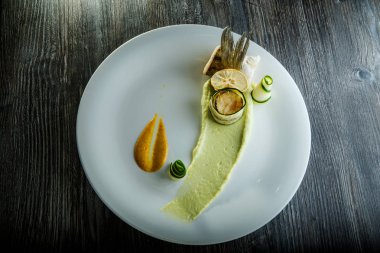 beyaz çanak üzerinde garnitür ile ince dekore edilmiş balık rulo üst görünümü